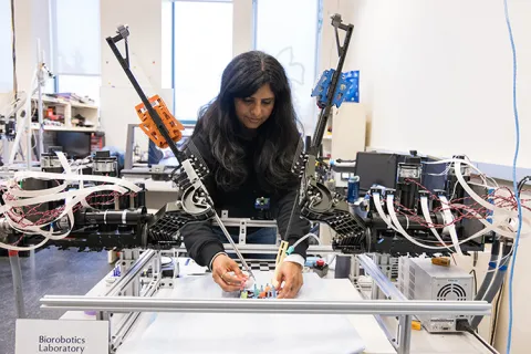 Niveditha Kalavakonda standing next to and setting up a surgical robot